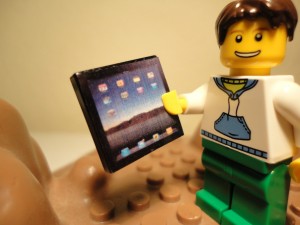 Lego man holds a miniature Lego iPad, his Lego hands have the perfect grip for iPad.