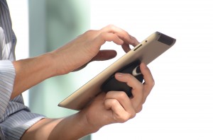Photo of hands holding and iPad using a Vacuum Dock as and iPad grip.